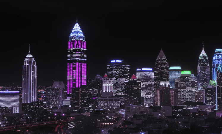 City skyline illuminated at night with brightly lit buildings.